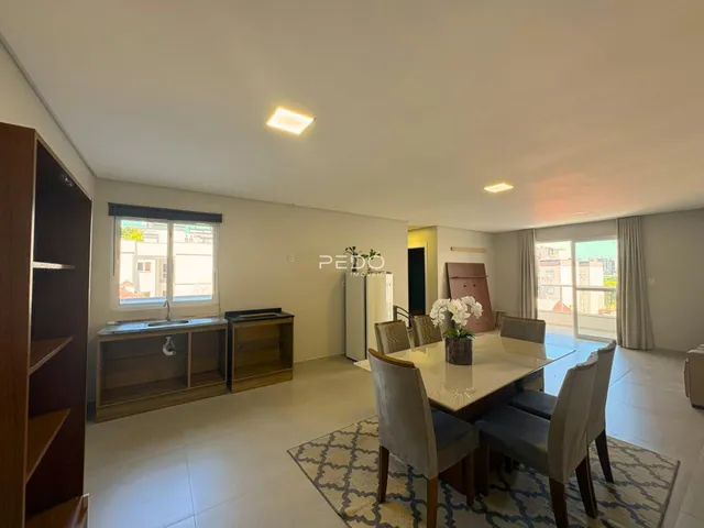 Sala de estar e jantar com móveis de madeira em um apartamento.