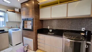 Cozinha com armários brancos e bancada preta.