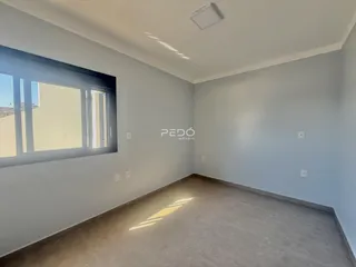 Ambiente interno de uma sala com paredes claras e piso de pedra.