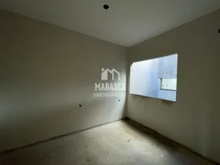 Interior de um cômodo com paredes brancas e piso de concreto.