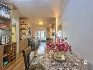 Interior de uma sala de estar com piso de madeira e estantes de madeira.