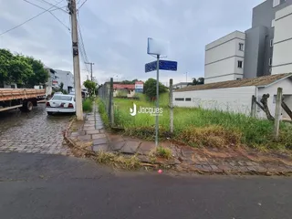 Vista da fachada de uma propriedade com calçamento e vegetação na frente.