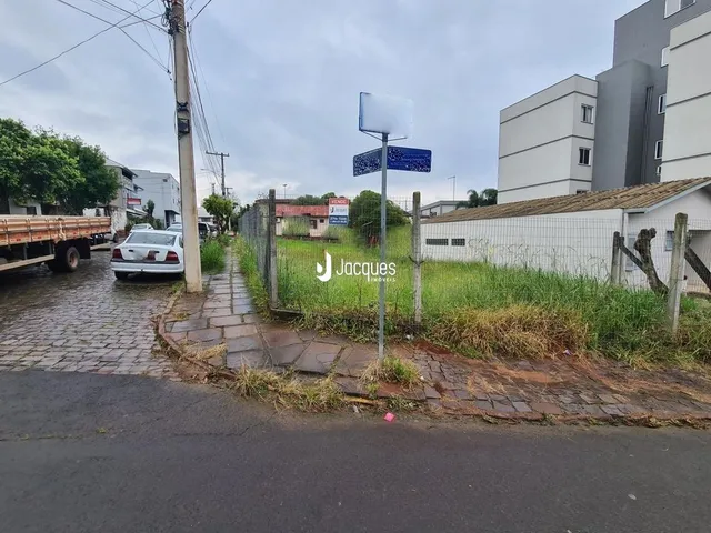 Vista da fachada de uma propriedade com calçamento e vegetação na frente.
