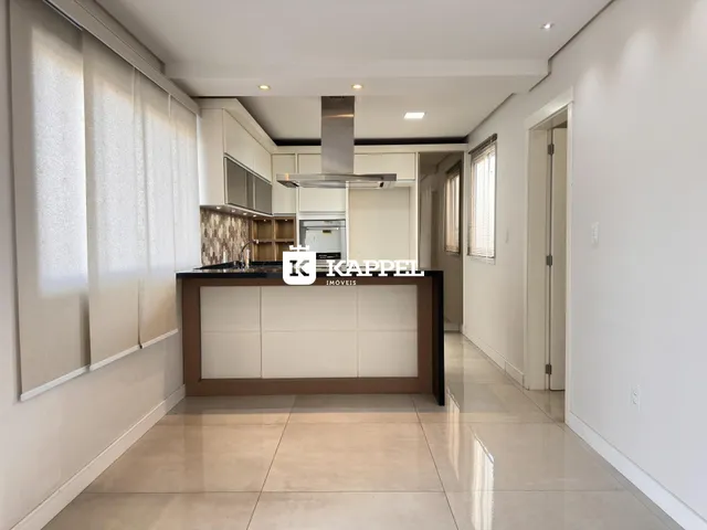 Foto de uma cozinha moderna com armários brancos e ilha central em um imóvel em Lajeado.