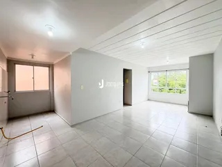 Interior de uma sala ampla com piso de cerâmica e janelas grandes.