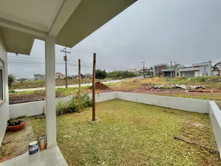 Vista do quintal com grama e postes de madeira