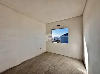 Foto de um ambiente interno com paredes brancas e piso de concreto.