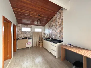 Interior de uma cozinha com piso de cerâmica e teto de madeira.