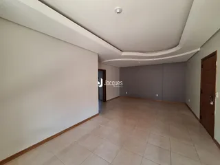 Interior de um corredor com piso de cerâmica claro e paredes brancas.
