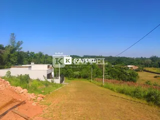 Vista aérea de uma área de campo aberto com vegetação seca sob um céu azul.