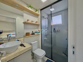 Foto de um banheiro moderno com box de vidro e bancada de mármore.