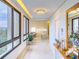 Hall de entrada com grandes janelas que oferecem uma vista externa.