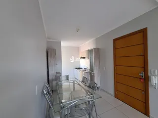 Hall de entrada com porta de madeira e mesa de vidro em um imóvel.