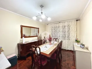 Uma sala de jantar com móveis de madeira e piso de madeira.