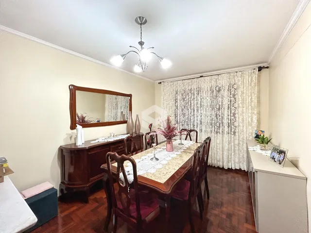 Uma sala de jantar com móveis de madeira e piso de madeira.