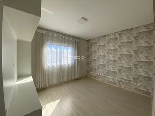 Sala de estar com piso de madeira clara e parede texturizada.