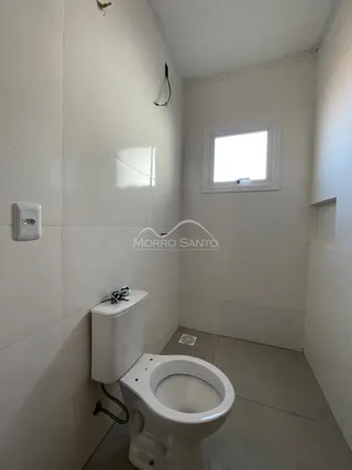 Foto de um banheiro com vaso sanitário branco e paredes brancas.