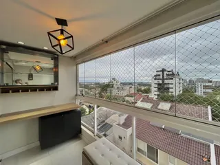 Vista da sala com grade de vidro mostrando telhados de Lajeado.