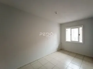 Ambiente interno de uma sala com piso de cerâmica clara e paredes brancas.