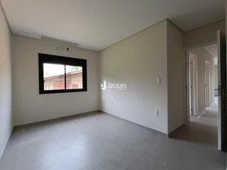 Ambiente interno de uma sala com paredes brancas e piso claro.