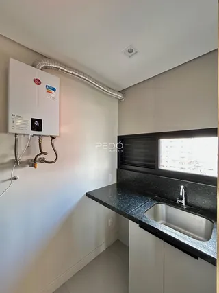 Vista da cozinha com bancada e pia em imóvel no Brasil.