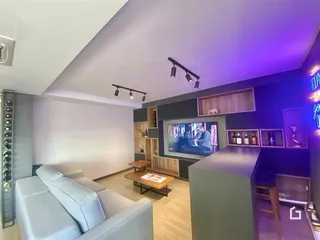 Sala de estar moderna com sofá e televisão em um apartamento.