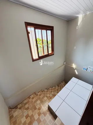 Vista de um canto de ambiente com janela de madeira em uma residência.