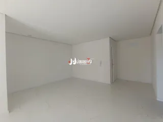 Foto de um ambiente interno vazio com paredes brancas.