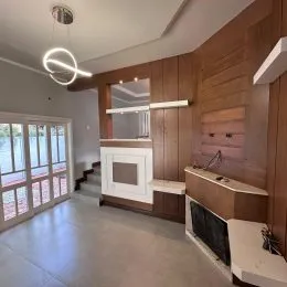 Uma sala de estar com painéis de madeira e lareira é visível na propriedade.