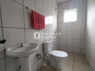 Foto de um banheiro com azulejos brancos e louças sanitárias.