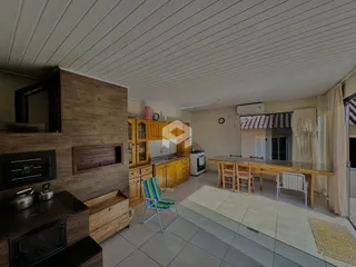 Interior de uma sala de estar com cozinha e área de jantar em Lajeado.