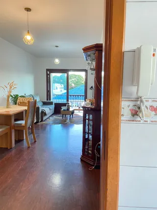 Sala de estar com piso de madeira e porta de vidro.