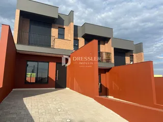 Fachada de uma residência em Lajeado, Brasil, com paredes alaranjadas.