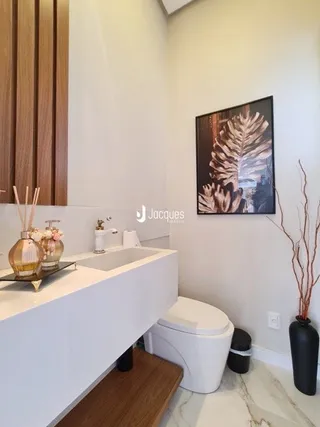 Foto de um banheiro moderno com bancada branca e vaso sanitário.