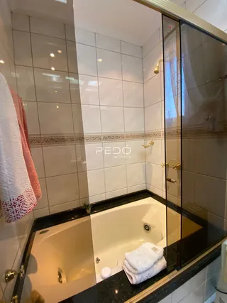 Foto de um banheiro com banheira e revestimento de azulejos brancos.