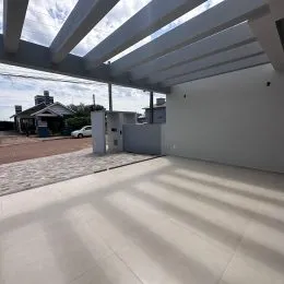 Foto de um ambiente interno com piso claro e estrutura de teto exposta.