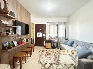 Sala de estar com sofá, televisão e móveis de madeira em um apartamento.