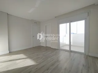 Vista interna de um ambiente com piso de madeira clara e portas brancas.