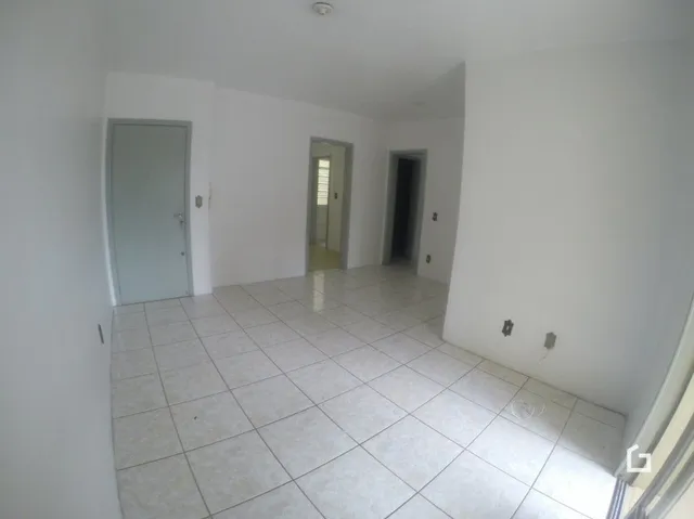 Corredor interno de uma residência com piso de cerâmica clara.