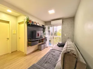 Sala de estar com piso de madeira e porta de vidro dando acesso a uma varanda.