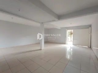 Ambiente interno amplo com piso de cerâmica e paredes brancas.