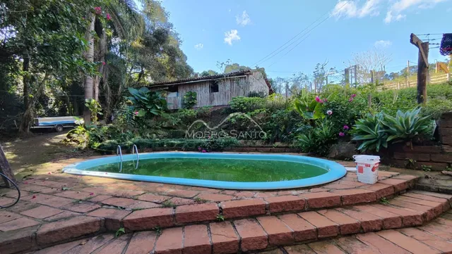 Foto de uma piscina externa cercada por degraus de tijolos em uma propriedade.
