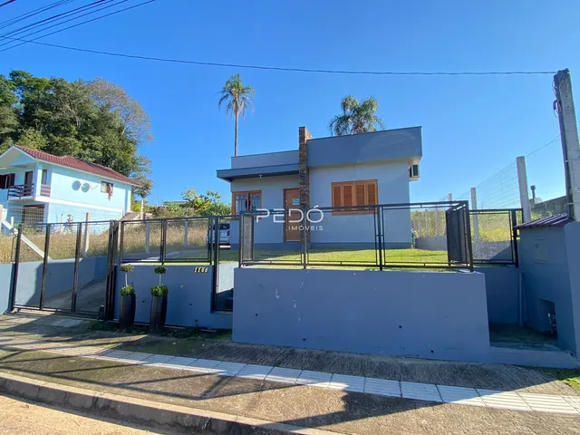 Fachada de uma casa em Lajeado, Brasil, com cerca e portão de ferro.