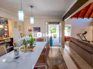 Uma sala de jantar com mesa branca e cadeiras estofadas é visível na propriedade.