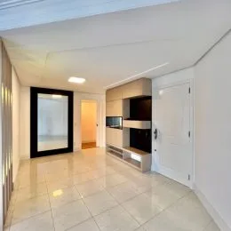 Hall de entrada com piso de cerâmica e paredes brancas.