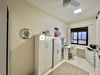 Quarto com armários brancos e iluminação clara.