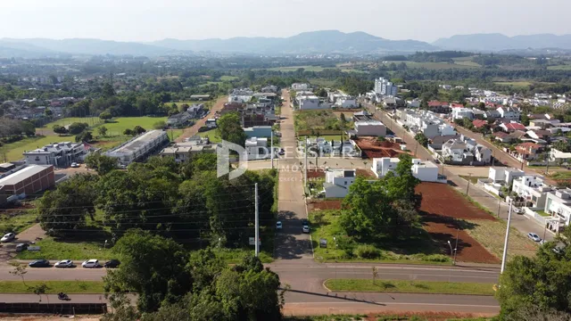 Vista aérea de uma área de terreno com vegetação e construções na paisagem.