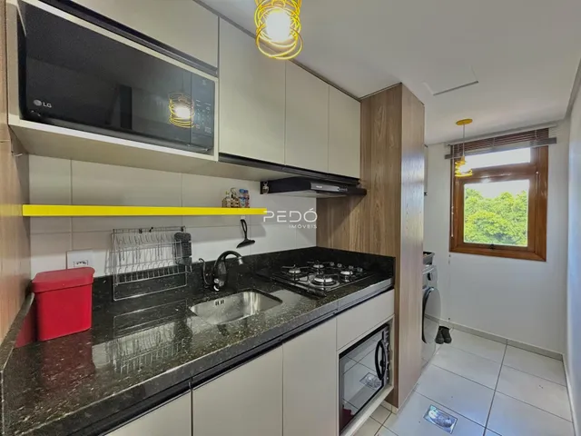Foto de uma cozinha moderna com armários brancos e bancada escura.
