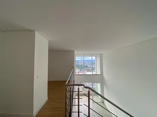 Um corredor com piso de madeira e vista para a paisagem urbana.