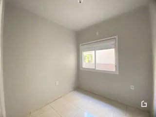 Imagem de um cômodo interno com paredes brancas e piso de cerâmica.